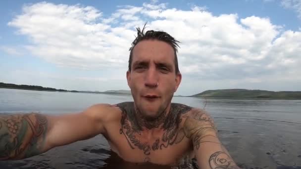 ชายหน มคนหน งลงในทะเลสาบต ในสว เดน าเย นมากและเขาม การแสดงออกท ตลกบนใบหน าของเขา — วีดีโอสต็อก