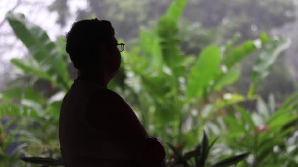 Anciana Silueta Casa Interior Mirando Lluvia Cayendo Cámara Lenta Exuberante — Vídeos de Stock