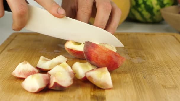 鋭いセラミックナイフで竹のまな板に果物をスライス — ストック動画