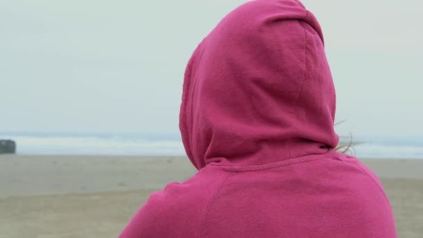 Девушка Пляже Маске Сзади Женщина Сидит Пляже Смотрит Море Капюшоном — стоковое видео