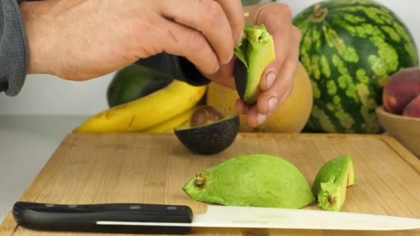 アボカドの皮は 新鮮なクリーミーな果物の塊から剥ぎ取られます キッチンの設定を閉じる — ストック動画