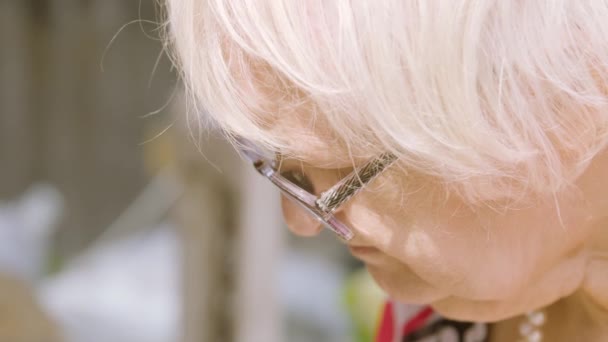 Закройте Лицо Пожилой Женщины Печатает Ноутбуке Саду — стоковое видео