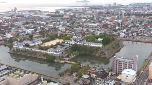 愛媛県今治市の賑やかな街の真ん中にある今治城の空中ドローンパン — ストック動画