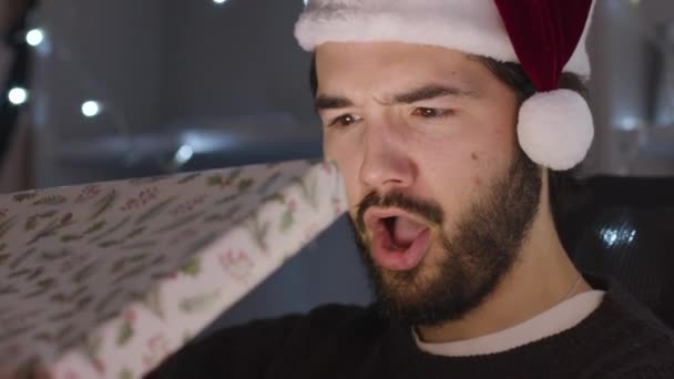 Mann Schockiert Und Überrascht Beim Öffnen Von Weihnachtsgeschenk Das Gesicht — Stockvideo