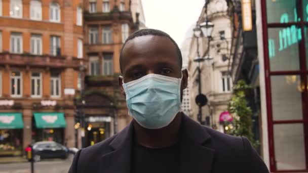 Pria Mengenakan Masker Medis Melihat Kamera Jalan London Yang Sibuk — Stok Video