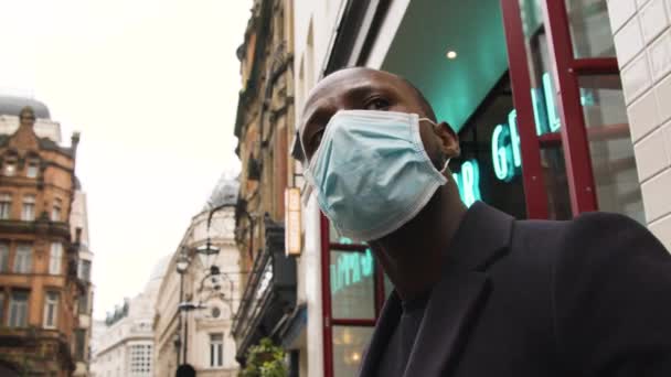 Mann Mit Medizinischer Maske Schaut Sich Einer Belebten Straße London — Stockvideo
