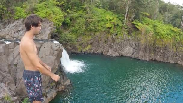 Człowiek Skacze Klifu Niebiesko Zielonej Wody Położony Hawajskiej Dżungli Wodospad — Wideo stockowe