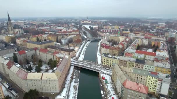 冬のチェコ共和国オロモウツの雪の降る建物や聖ヴァーツラフ大聖堂のカラフルな屋根の上の空中ドローン — ストック動画