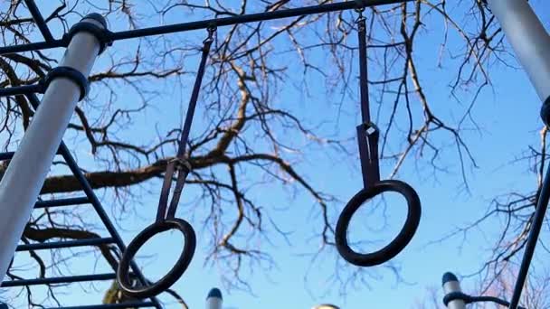 Pierścienie Gimnastyczne Poruszają Się Wietrze Drzewami Niebieskim Niebem Tle Stały — Wideo stockowe