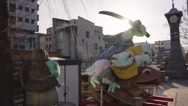 長野県松本市 太陽が侍カエル像の上に設定4K — ストック動画