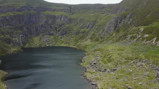 アイルランドのウォーターフォードにあるクムシニョーン ドローンは 湖の向こうの崖から飛んでいく 湖は山に囲まれている 旅行とハイキングのコンセプト — ストック動画