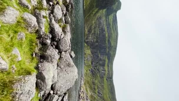 アイルランドのウォーターフォードにあるクムシニョーン 湖の手すりに向かって歩く 山に囲まれて スローモーション 旅行とハイキングのコンセプト — ストック動画