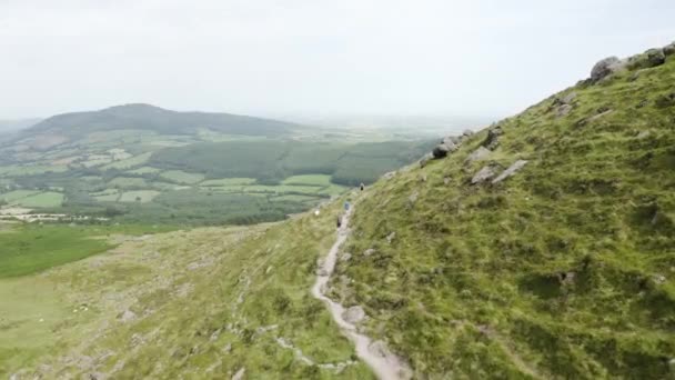 アイルランドのウォーターフォードにあるクムシニョーン 山沿いのハイキングコースを歩く人々の空中ビュー 旅行とハイキングのコンセプト — ストック動画