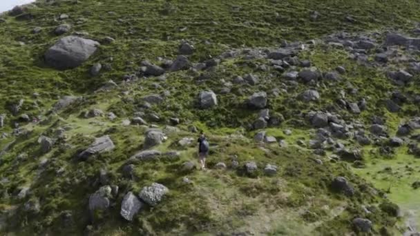 ドローンは山のハイキングコースでハイカーの上に乗ります アイルランドのウォーターフォードにあるクムシニョーン 旅行とハイキングのコンセプト — ストック動画