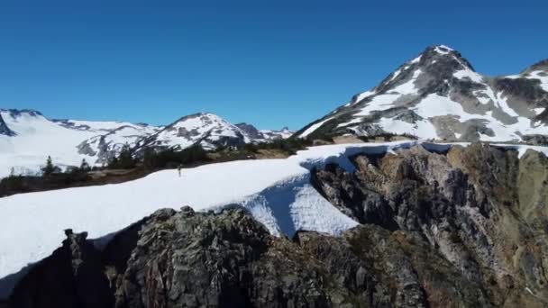 在加拿大不列颠哥伦比亚省的太平洋山脉山顶上 一名飞行员在雪地中行走 — 图库视频影像