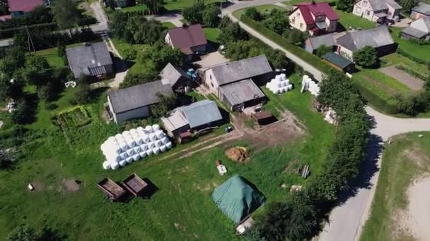 用塑料包裹着一捆捆干草的村庄房屋的无人机射击 立陶宛 Zemaiciu Naumiestis — 图库视频影像