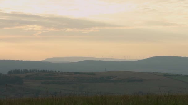 地平线4K上有风力涡轮机农场的草甸美丽的日出 — 图库视频影像