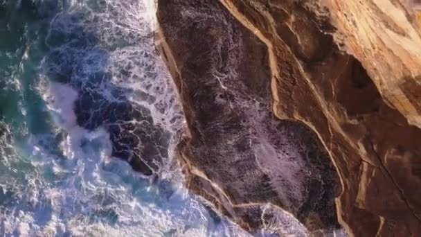 強力な海の波が岩や崖をクラッシュし 空中のトップダウン上昇を明らかにショットを明らかに — ストック動画