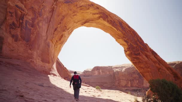 在Corona Arch Moab下行走的远足者 — 图库视频影像