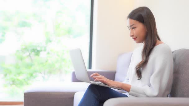 Close Uma Jovem Mulher Sentada Sofá Digitando Laptop Equilibrado Suas — Vídeo de Stock