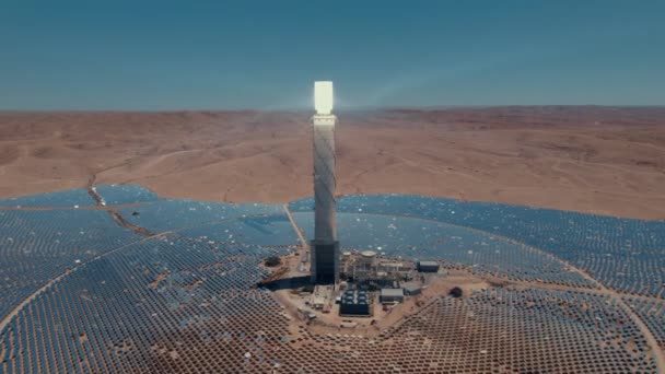 太陽光発電塔は 雲のない日に砂漠の太陽の下での可動ミラーのための太陽光に焦点を当てた 遅い追跡パララックスドローンショット — ストック動画