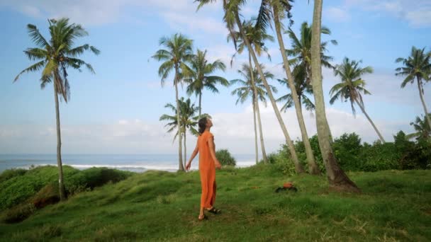 Ευρύ Πλάνο Του Ευτυχισμένη Νεαρή Γυναίκα Πορτοκαλί Φόρεμα Περιστρέφεται Μεταξύ — Αρχείο Βίντεο