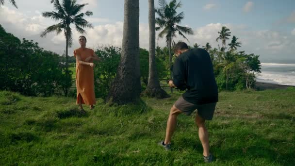 Videograf Filmt Modell Mit Palmen Strand Meer Hintergrund Weite Umlaufbahn — Stockvideo