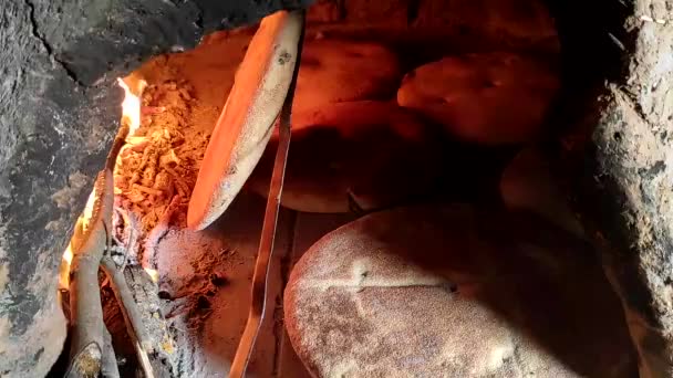 薪窯で伝統的な焼き方でパンを焼き 床に平パンを調理します ヴィンテージスタイルによるモロッコ料理や東洋料理の文化 — ストック動画