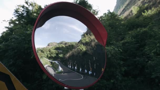 圆圆的交通凸面镜安装在山路的发夹弯上 凸面镜反映了经过的车辆 它被放置在战略地位 以避免车辆碰撞 — 图库视频影像