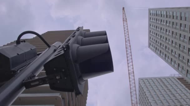 現代的な街並みスカイライン超高層ビル建設クレーンと交通信号曇りの空を見上げます スマートシティ5G Ai接続コンセプト — ストック動画