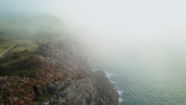 霧に覆われた海の空中ビュー スペインのカンタブリア州のUbiarcoで霧の多い環境で波 背景の山の範囲 ドローン軌道撮影 — ストック動画