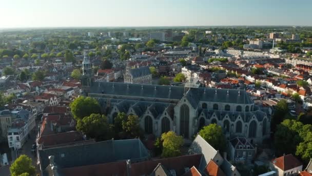 オランダの後宇多市にある旧市庁舎を背景にした聖ヨハネ教会の空中ドローンビュー — ストック動画