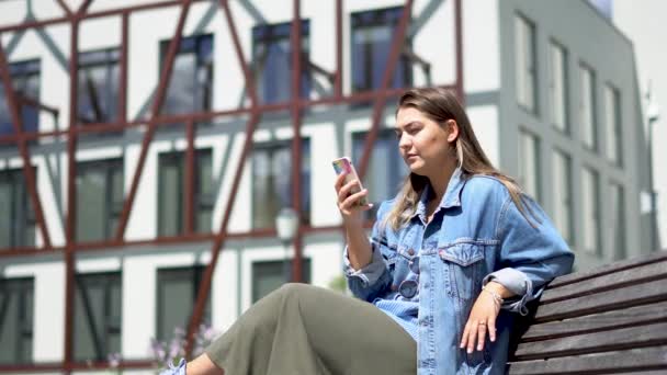 Meisje Verrast Met Het Bericht Haar Telefoon Zittend Een Bank — Stockvideo