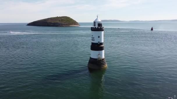 ペンモン灯台の空中ビューのランドマークパフィン島透明なターコイズブルーのウェールズの海の風景がゆっくりと引き離されます — ストック動画