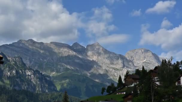 阿尔卑斯山中的瑞士石山 隐隐约约 多云的天空 右边的小村庄 经过的时间 — 图库视频影像