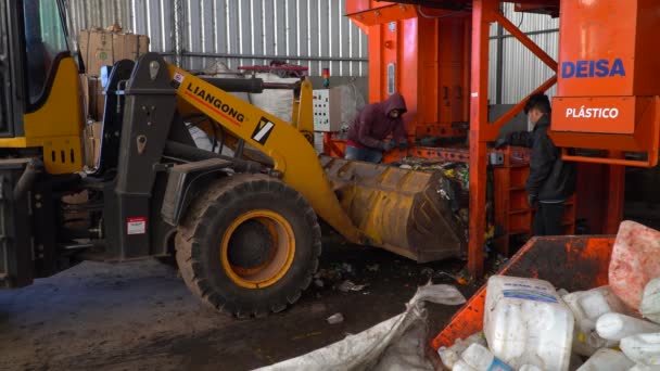 Dwóch Pracowników Ładuje Buldożer Zagęszczonymi Śmieciami Wewnątrz Zakładu Przetwarzania Odpadów — Wideo stockowe