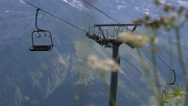 前景のポールと花とスイスのアルプスのチェアリフトのインストール Obwalden Engelberg — ストック動画