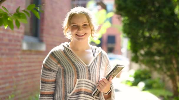 Μια Φοιτήτρια Χαμογελάει Στην Κάμερα Κρατώντας Σημειωματάριο Αργή Κίνηση — Αρχείο Βίντεο