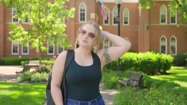 Een Studente Met Een Rugzak Met Een Zonnebril Glimlacht Voor — Stockvideo