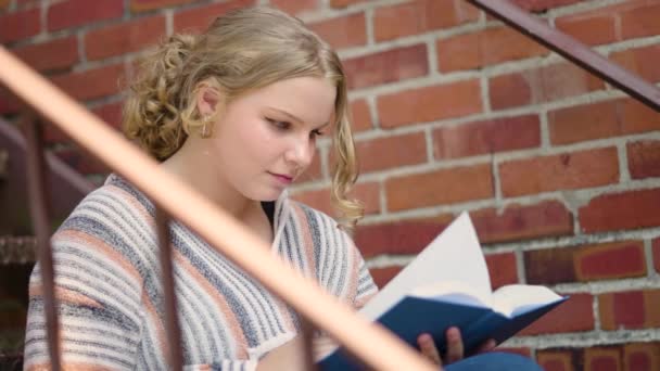 Girl Student Reads Book Turns Pages Sitting Stairs Next Brick — Stock Video