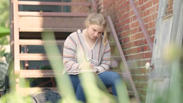 Chica Estudiante Escribe Bloc Notas Mientras Está Sentado Escaleras Metal — Vídeos de Stock