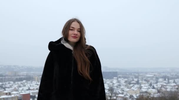 雪の中黒の冬のコートの外に立つ若い女性モデル — ストック動画