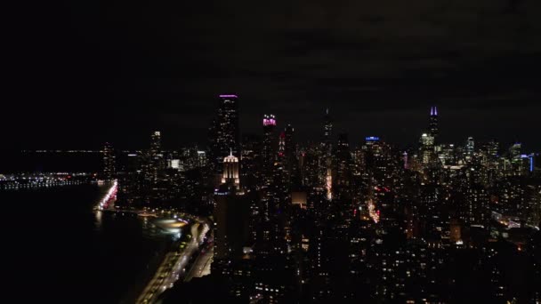 10月 一架无人驾驶飞机占领了伊利诺伊州芝加哥的多座灯火辉煌的建筑物或天际线 以及沿着高速公路和一个可爱的湖面行驶的几辆车 — 图库视频影像