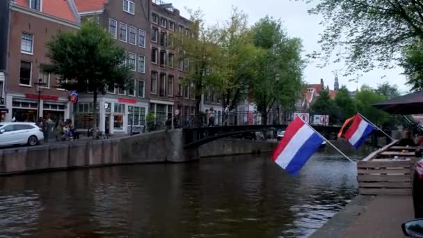 絵のように美しい鉄橋に向かってアムステルダム運河のクラシックボート昼間 手持ち撮影 — ストック動画