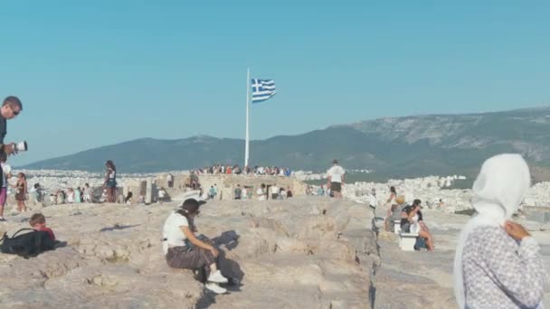 Turistas Sentados Alrededor Bandera Griega Sobre Acrópolis — Vídeo de stock