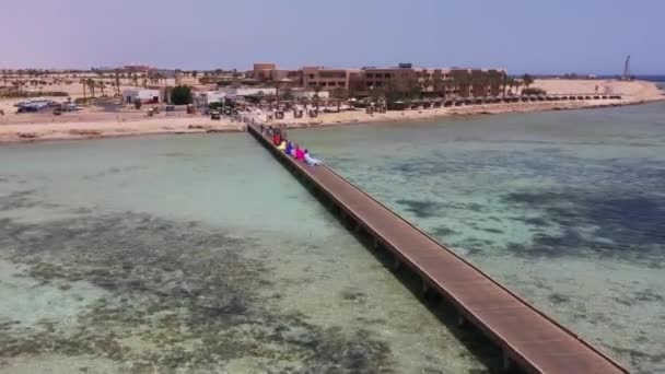 Aerial Drone Shot Kobiet Sukienkach Wzdłuż Plaży Molo Morzu Czerwonym — Wideo stockowe