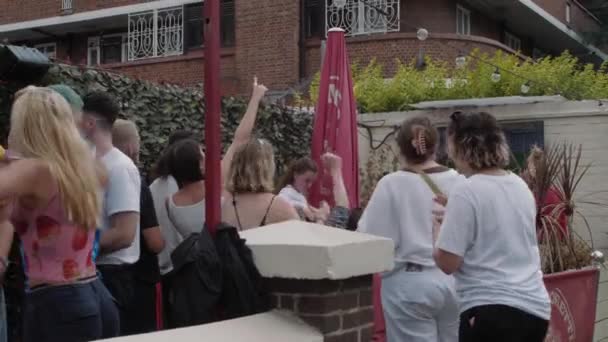 イングランドの女子ユーロ決勝パブ目標を祝う屋外の人々 — ストック動画