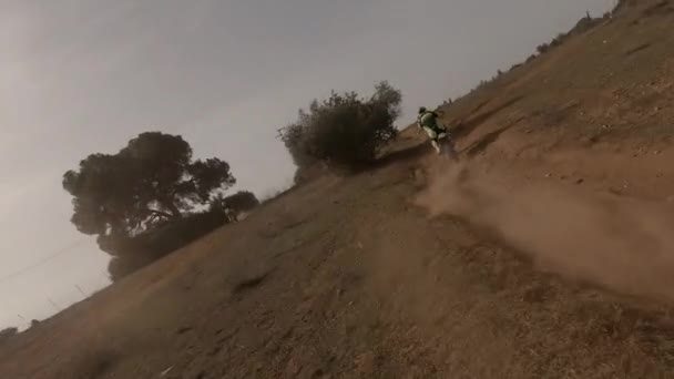 Fpvドローンは黄金の砂のレーストラック上のモトクロスダートバイクライダーを追いかける — ストック動画