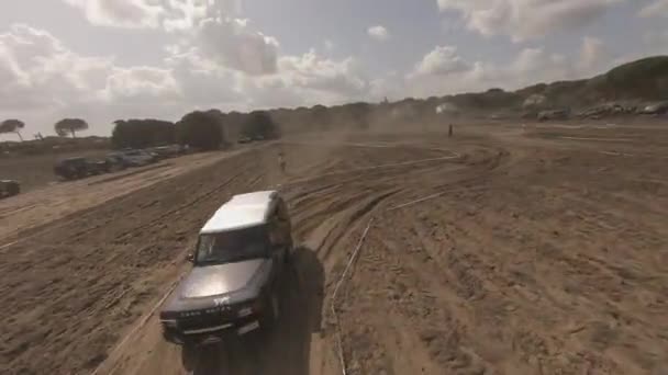 Fpv Drone Orbits Land Rover Sandy Iberlince Road Race Course — Stock Video