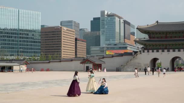 ソウルの景福宮で撮影した韓服姿の彼女たち 光化門と市の建物を背景に — ストック動画